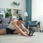 a man sitting on the floor with a pair of shoes