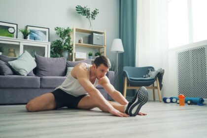 a man sitting on the floor with a pair of shoes