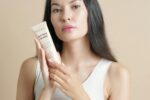Woman holding a tube of facial cleanser