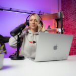 a woman sitting in front of a laptop computer