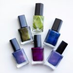 a group of five different colored nail polishes