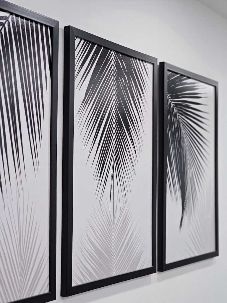 three black and white paintings hanging on a wall